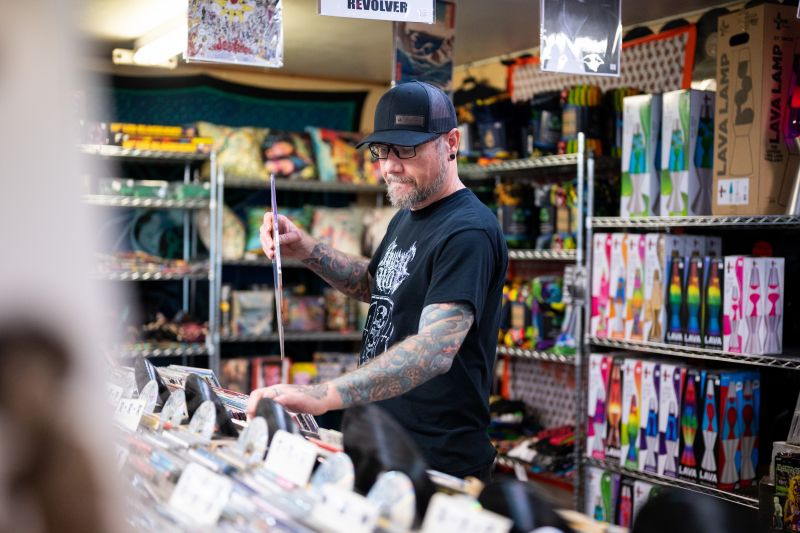 Keith Coombes in black t-shirt black hat sorts records at Ernie November downtown Rapid City